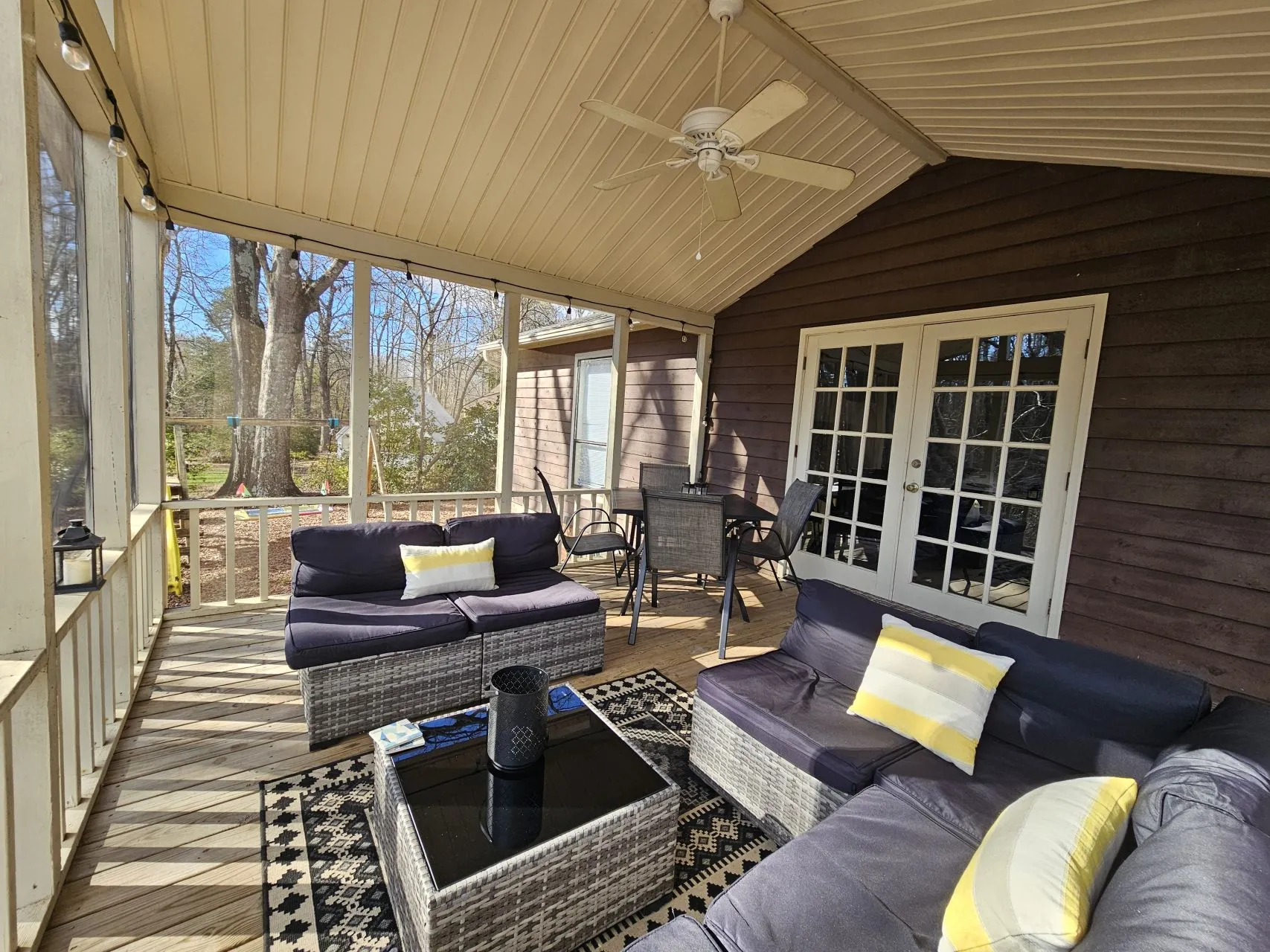 Screened porch with comfortable seating and forest views